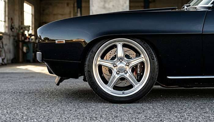 Pro-touring muscle car with 18 inch wheels and low-profile performance tires showing aggressive modern stance