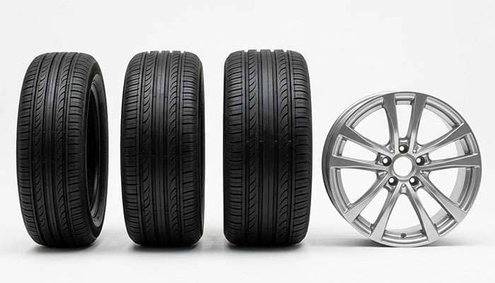 Three 18-inch tires of different section widths lined up beside an 8-inch wide wheel for size comparison