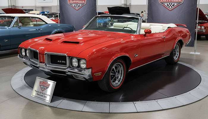 Red 1970 Oldsmobile 442 W-30 convertible with white interior and black accents displayed at the 2022 Muscle Car and Corvette Nationals