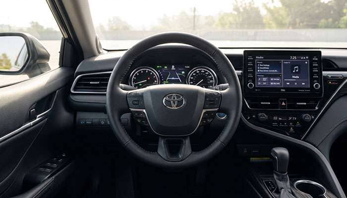Interior view of the 2025 Toyota Camry SE focusing on the steering wheel and dashboard controls