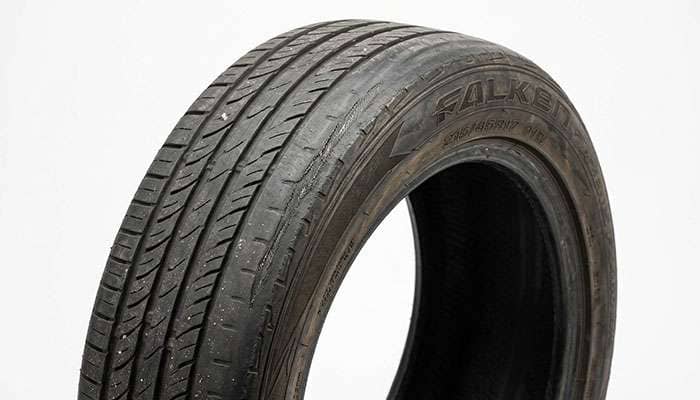 Worn 215/45R17 tire showing accelerated outer shoulder wear from operating above its rated load