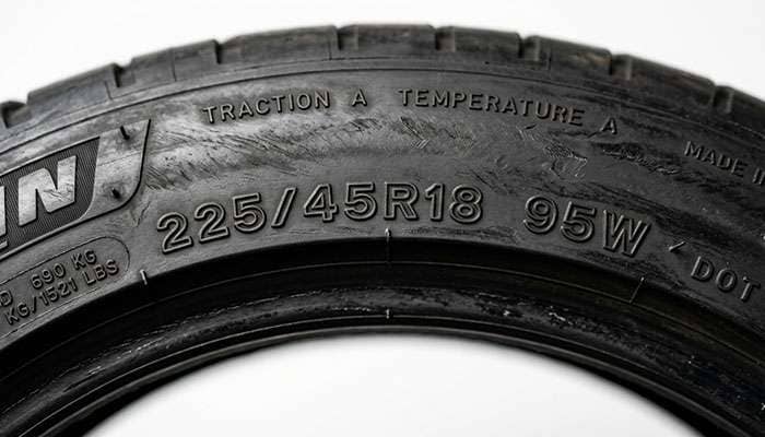 Close-up of a tire sidewall showing the 225/45R18 size marking with the load index and speed rating