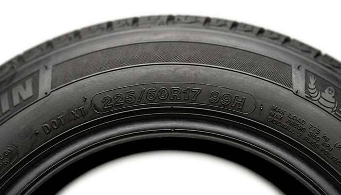 Close-up of a 225/60R17 tire sidewall showing the 99H load index and speed rating marking