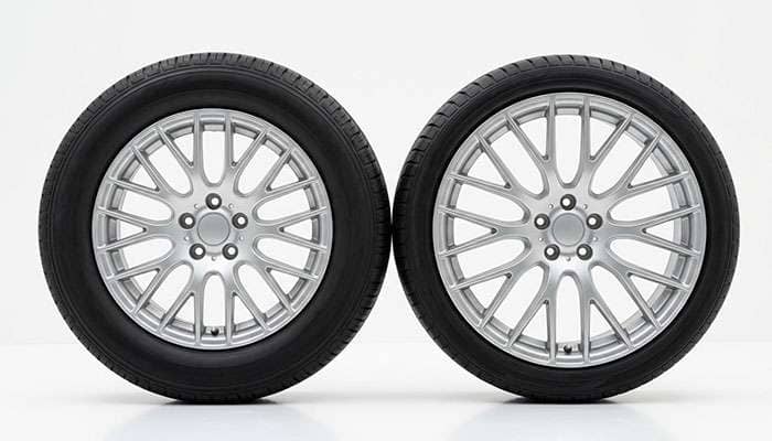 Two tires of matching overall diameter side by side, one on a seventeen inch wheel with a taller sidewall and one on an eighteen inch wheel with a short sidewall