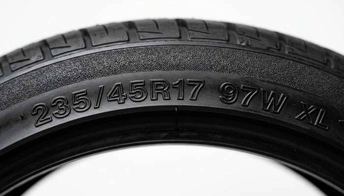 Close-up of a 235/45R17 tire sidewall showing the 97W XL load index and speed rating markings
