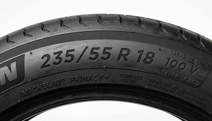 Close-up of a tire sidewall showing the 235/55R18 size markings