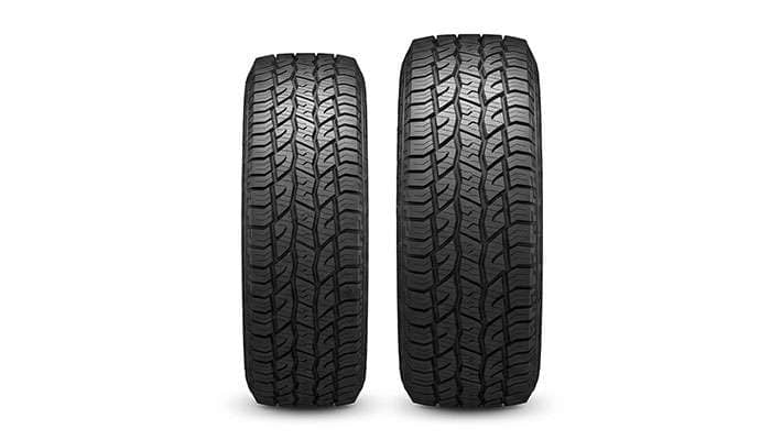 Two tires standing side by side comparing a narrower 215/70R16 against a wider 235/70R16 showing the difference in width and height
