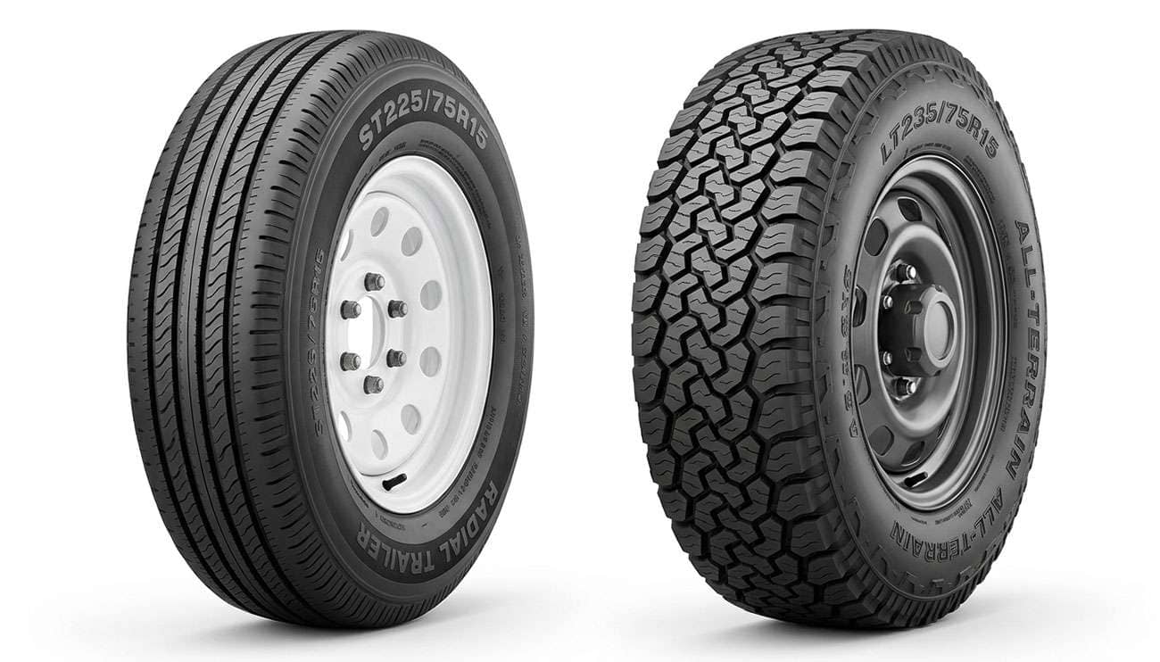 ST225/75R15 trailer tire beside a 235/75R15 light truck tire on 15-inch wheels, comparing size and sidewall construction