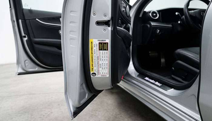 Driver door jamb tire and loading information placard showing tire size and cold inflation pressure
