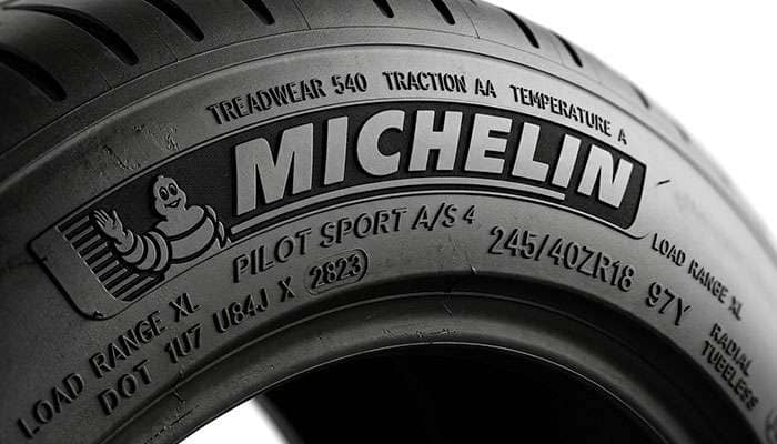 Close-up of a 245/45R19 tire sidewall showing the service description load index and speed rating markings