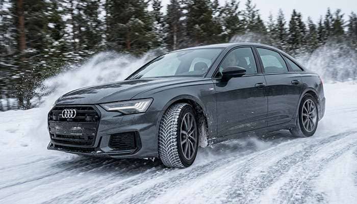 Performance sedan fitted with 245/45R19 winter tires driving on a snow covered road