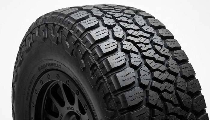 All-terrain tire tread pattern with staggered shoulder blocks and stone ejectors