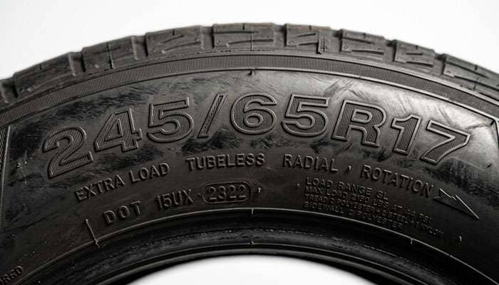 Close-up of a 245/65R17 tire sidewall showing the size and load index markings