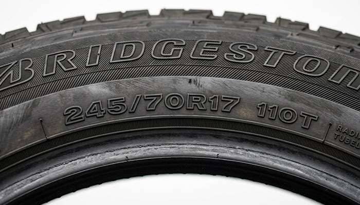 Close-up of a truck tire sidewall showing the 245/70R17 size marking alongside the load index and speed rating