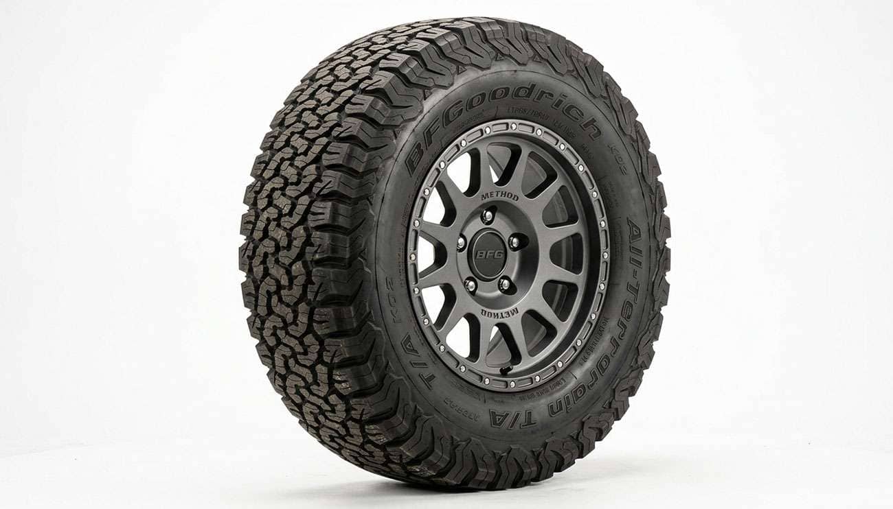 A 245/70R17 all-terrain truck tire mounted on a dark alloy wheel on a clean white seamless backdrop