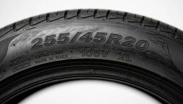 Close-up of a tire sidewall showing the 255/45R20 size marking with load index and speed rating