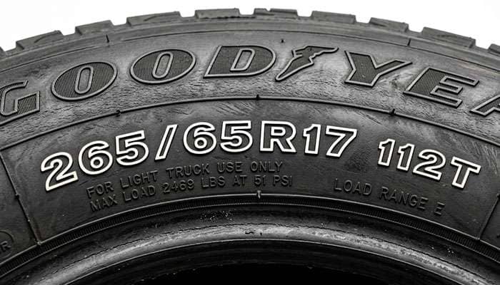 Close-up of tire sidewall showing 265 65R17 size marking and service description