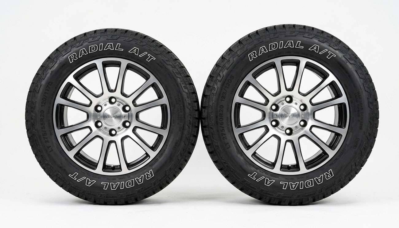 275/55R20 and 275/60R20 truck tires standing side by side showing the difference in sidewall height