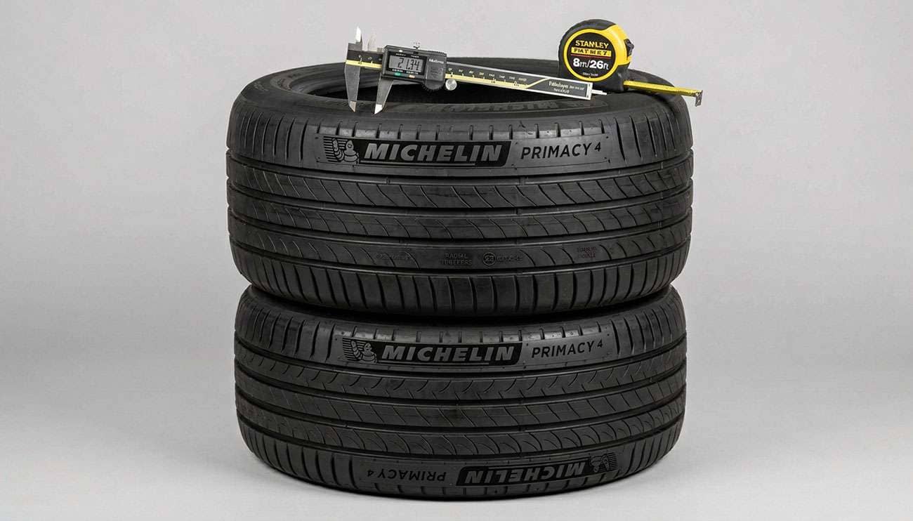 Vintage tire shop counter with stacked tires, measuring calipers, and shop manuals under warm overhead lighting