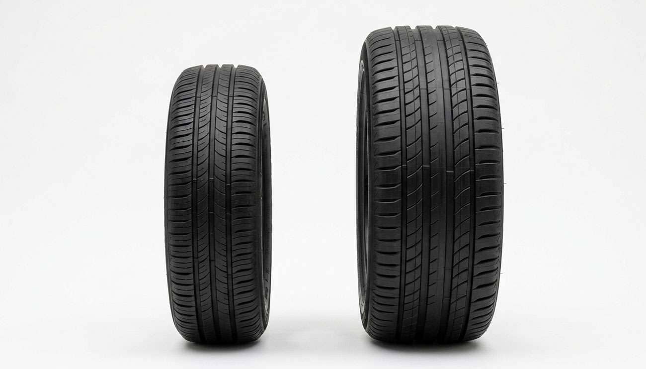 A 15-inch economy car tire standing next to a 20-inch SUV tire showing the size difference behind tire prices