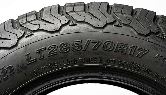 Close-up of a light truck all-terrain tire sidewall showing the size code, load index, and load range markings