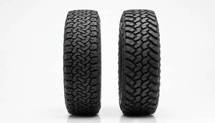 Side-by-side comparison of an all-terrain and a mud-terrain 35 inch tire showing the difference in section width and shoulder design