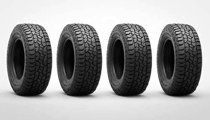 Four 35x12.50R18 all-terrain tires displayed on a desert road with bold red and black text above them