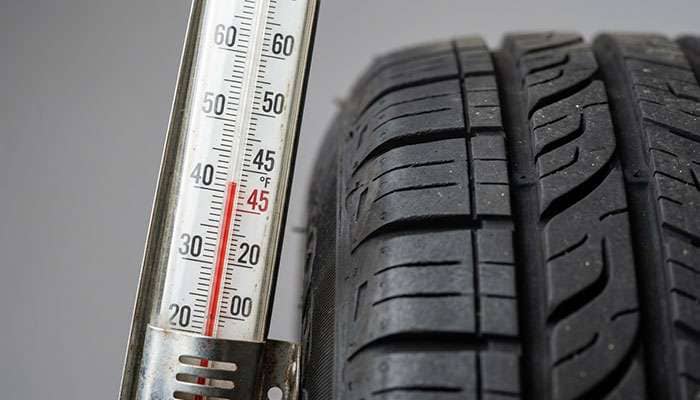 Thermometer at 45 degree Fahrenheit threshold with tire tread pattern detail overlay
