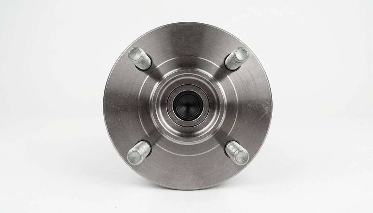 Four lug wheel hub with the studs exposed, photographed straight on to show the bolt pattern spacing, on a clean white seamless backdrop