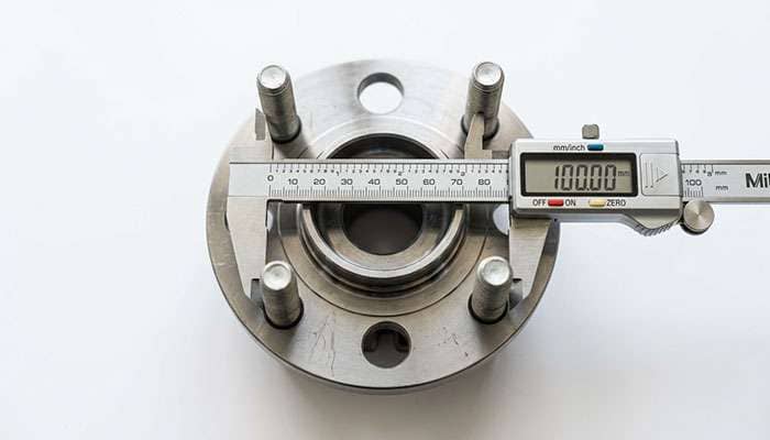 Diagram style photograph of a four lug wheel hub with the pitch circle diameter measured between opposite stud centers
