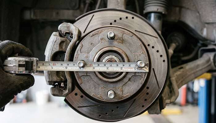 Tape measure spanning two opposite studs on a four-lug UTV hub