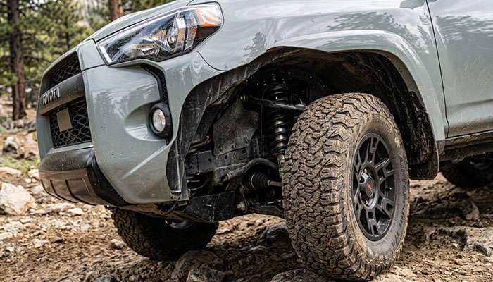 Front wheel of a 5th gen Toyota 4Runner turned to full lock with a 285/70R17 all-terrain tire and the mud flap removed