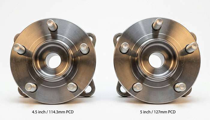 Two five-lug wheel hubs side by side showing the difference between a 105mm bolt circle and a 115mm bolt circle