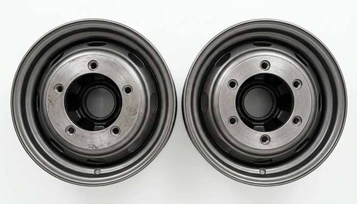 Five-lug and six-lug truck wheels photographed from behind side by side to compare bolt circle and stud count