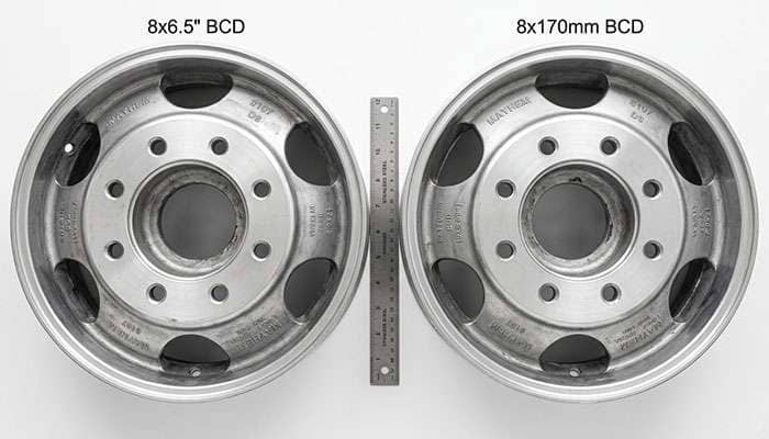Two dually wheels laid side by side showing the small difference between an eight on 200 millimeter and eight on 210 millimeter bolt circle