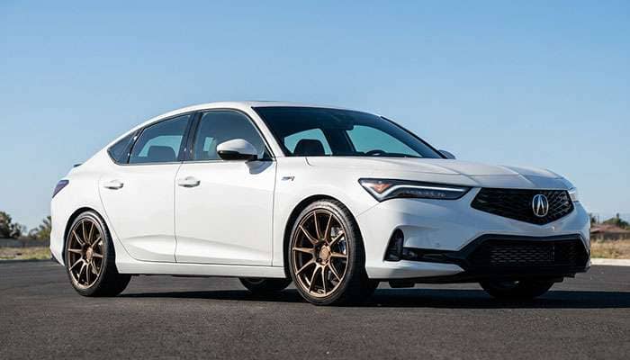 White Acura DE5 Integra Type-S sedan showcasing custom bronze wheels and tire fitment on a sunny day