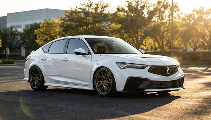 White Acura Integra Type S parked outdoors with bronze wheels and bold yellow Integra Type S Wheel Fitment text overlay