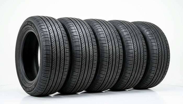 Row of affordable all-season passenger tires lined up on a clean white studio backdrop