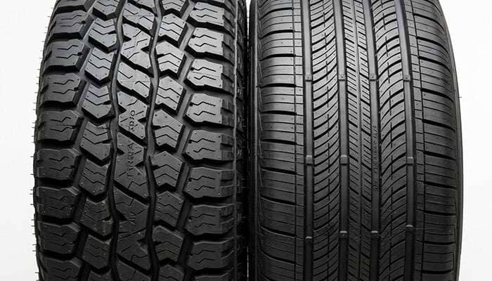 Close-up comparing the aggressive all-terrain tread to the smoother all-season tread