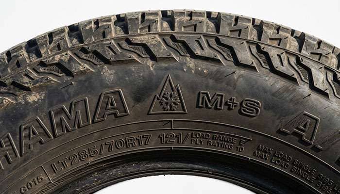 Close-up of an all-terrain tire sidewall showing the three-peak mountain snowflake symbol next to the M+S marking