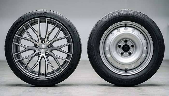 side by side comparison of a modern aluminum alloy wheel and a basic steel wheel showing the difference in design and construction