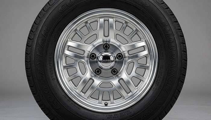 Close-up view of an aluminum mod-style trailer wheel showing the cast aluminum construction with machined spoke pattern and polished or clear-coated finish