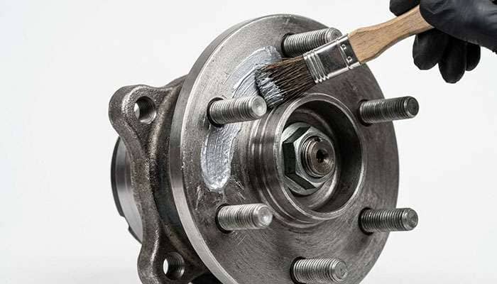 Anti-seize compound being applied with a small brush to a clean wheel hub face