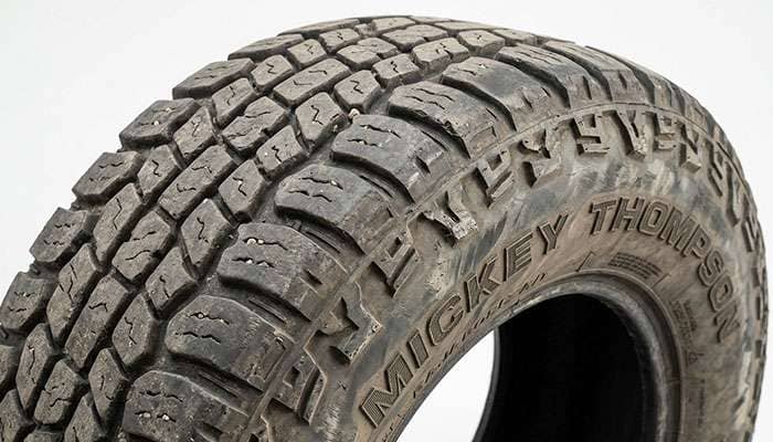 Close-up of a worn Mickey Thompson Baja Boss A/T tire shoulder showing tread block wear