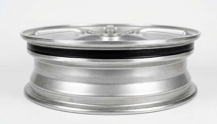 aluminum wheel bead seat after corrosion removal showing a smooth sanded surface coated with black bead sealant ready for tire mounting