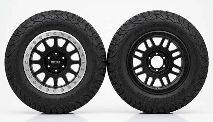 True beadlock off-road wheel next to a simulated beadlock wheel showing the functional ring versus decorative bolts on a clean white surface