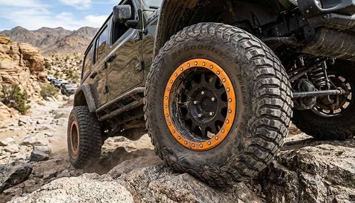 Beadlock wheel with outer ring mechanically clamping the tire bead on an off-road vehicle aired down for trail use