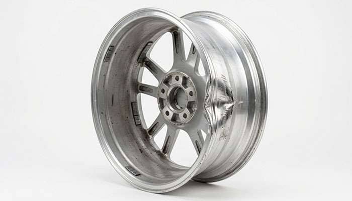 rear view of an aluminum wheel showing a folded inner lip flange hidden on the inboard side next to an undamaged outer lip
