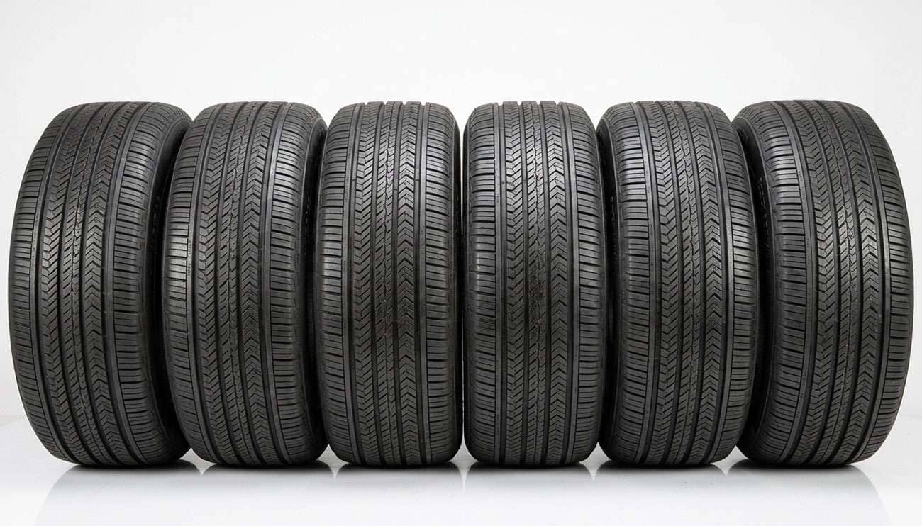 Row of 235/55R19 crossover tires from multiple brands lined up on a clean showroom floor