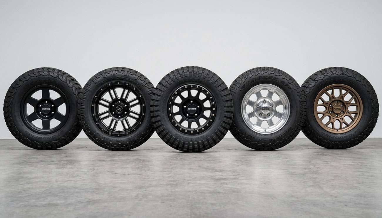 Five aggressive off-road wheels from leading brands arranged in a row showing different construction methods and finishes